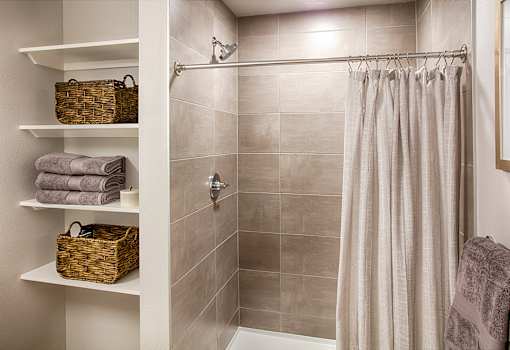 A bathroom with a shower curtain and towels.
