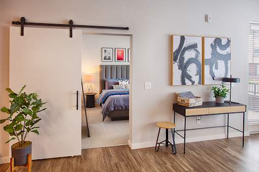 A room with a bed, desk, and chair.