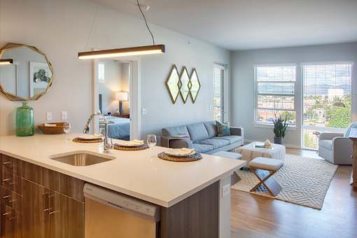A modern kitchen with a large island and a dining area with a couch and chairs.