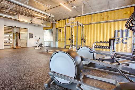 A gym with a row of exercise equipment.