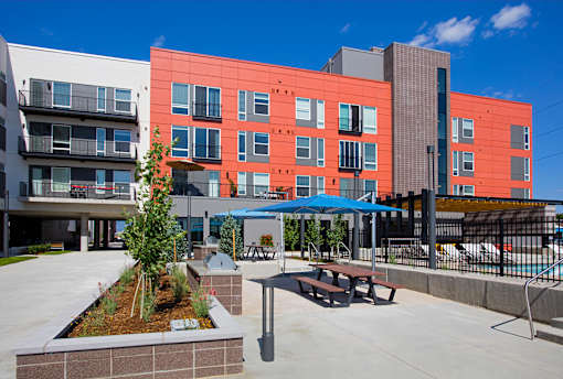 A red building with a blue umbrella in front of it.
