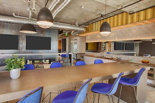 A conference room with a long table and blue chairs.