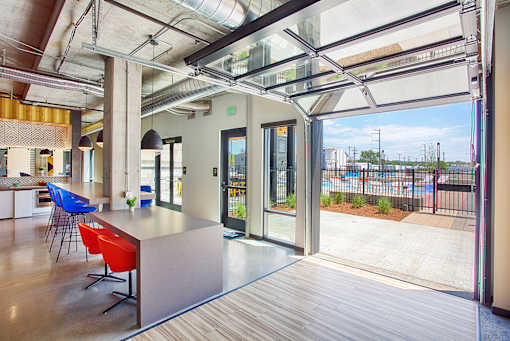A modern office space with a reception desk and a view of the outdoors.