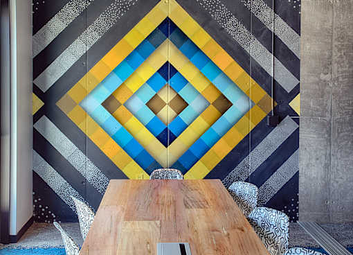 A wooden table is in front of a wall with a diamond pattern.