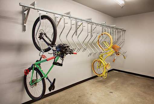 A bike rack with bikes of different colors hanging on it.