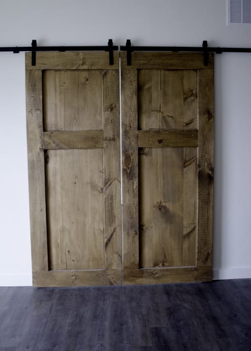 an image of a pair of wooden doors on a black rail