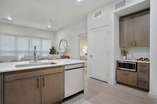 A modern kitchen with a white countertop and brown cabinets.