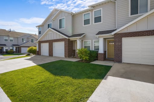 the front of a house with a driveway and lawn