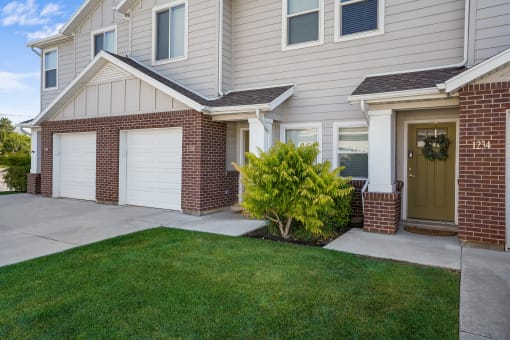 the front of a house with a driveway and two garage doors