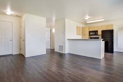 A kitchen area with a white counter and a black fridge.