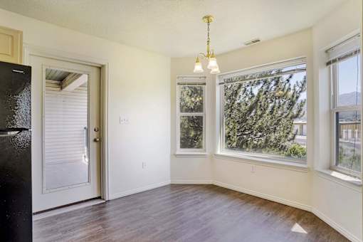 A room with a door, a window, and a chandelier.