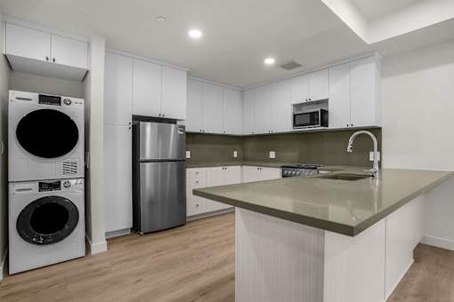 A modern kitchen with a large island and stainless steel appliances.