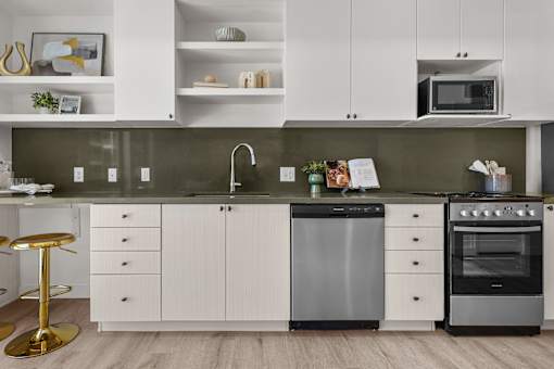 A modern kitchen with white cabinets and a black dishwasher.