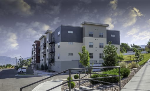 a rendering of an apartment building with a cloudy sky in the background