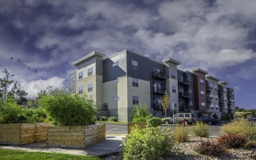 a rendering of an apartment building with a cloudy sky in the background