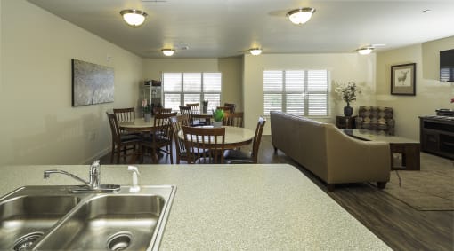 a kitchen with a sink and a table with chairs