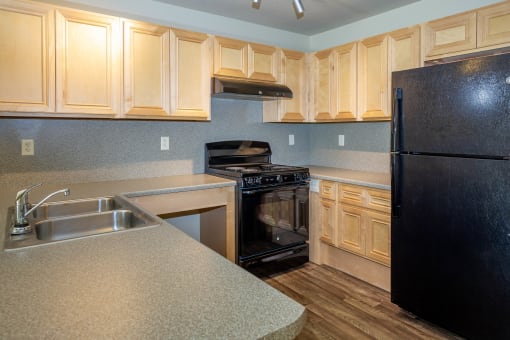 a kitchen with wooden cabinets and black appliances