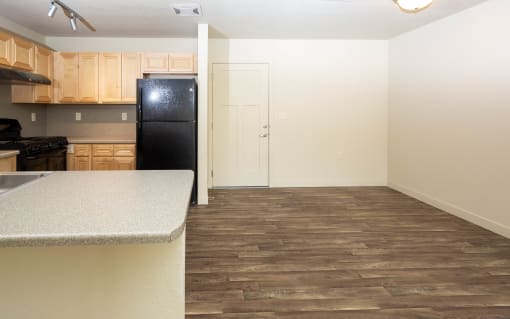 a kitchen and living room with wood floors and white walls