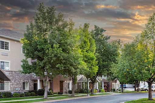 A row of houses with trees in front of them.