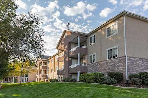 A large apartment complex with a green lawn in front.