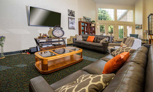 A living room with a large leather couch and a wooden coffee table.
