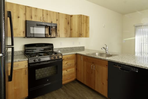a kitchen with black appliances and granite countertops