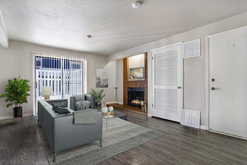 A living room with a grey couch and a fireplace.