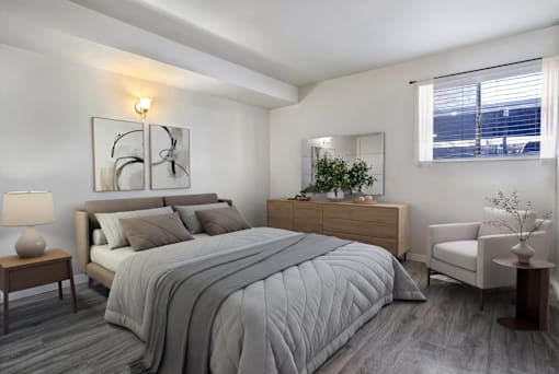 A bedroom with a large bed, a nightstand, and a chair.