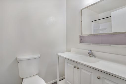 A white toilet sits next to a white sink in a bathroom.