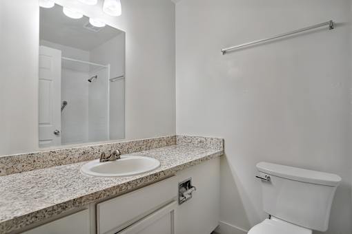 A white toilet sits next to a sink in a bathroom.