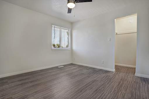 A room with a window and a wooden floor.