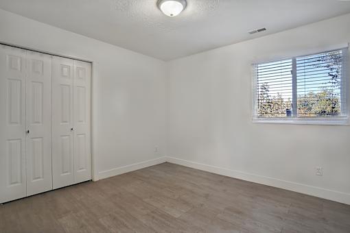 A room with a window and a wooden floor.