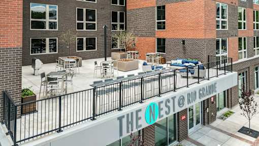 The Nest @ Rio Grande is a modern building with a balcony and outdoor seating area.