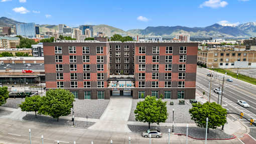 A large red brick building with a parking lot in front of it.