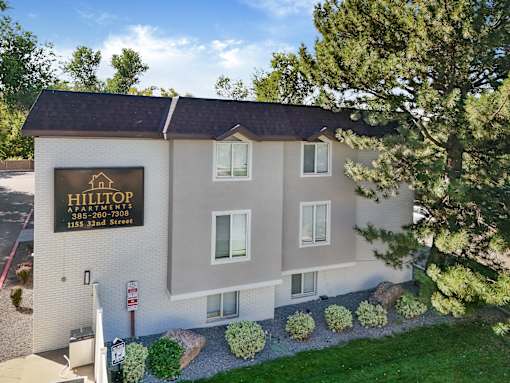 A building with a sign that says Hilltop Apartments.