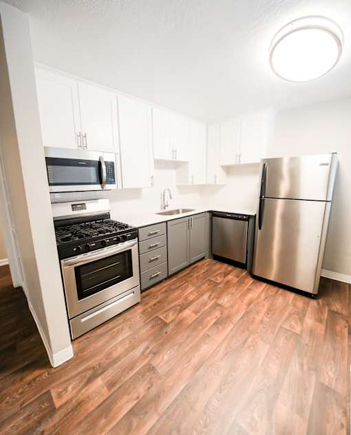 A kitchen with a stainless steel refrigerator, oven, and microwave.