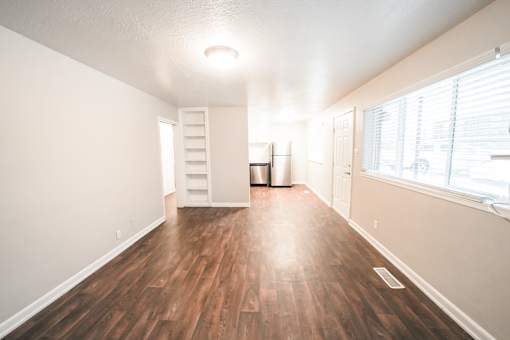 A room with wooden floors and a white wall.