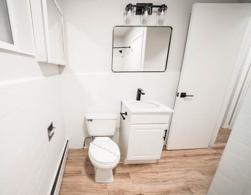 A white toilet and sink in a small bathroom.