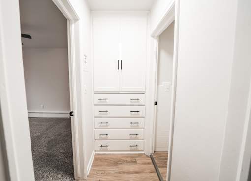 A white cabinet with drawers is in a room.