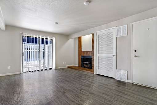 A room with a fireplace and sliding glass doors.