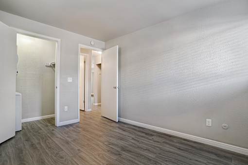 A room with a white wall and a wooden floor.