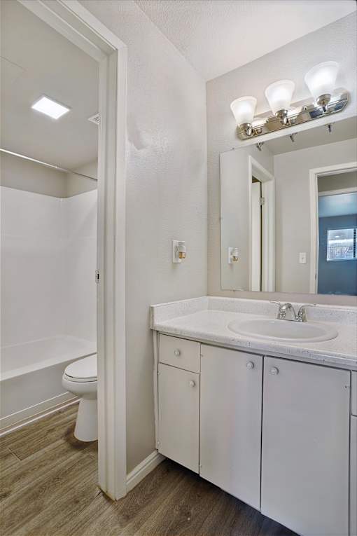 A white bathroom with a sink, toilet and mirror.