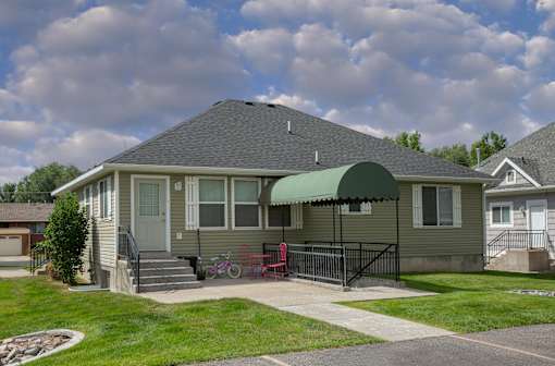 a house with awning in front of a yard