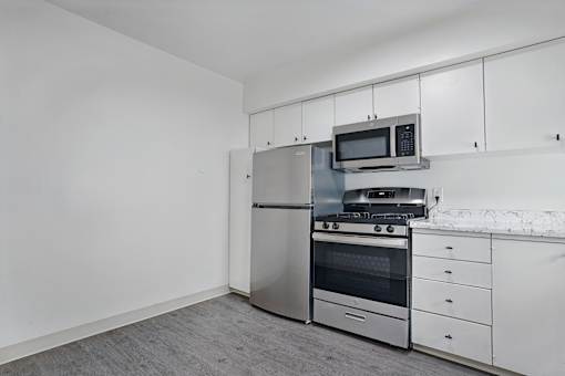 A kitchen with a stainless steel refrigerator, oven, and microwave.