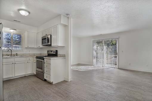 A kitchen with white cabinets and a microwave on the counter.