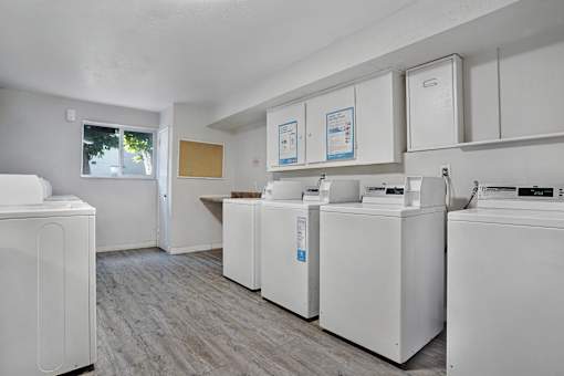 A laundry room with a washer and dryer on the left and a washer and dryer on the right.
