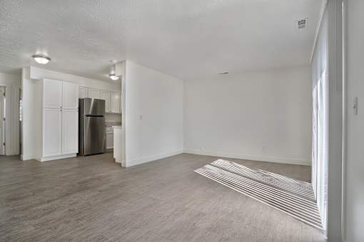 A kitchen with white cabinets and a refrigerator is visible.