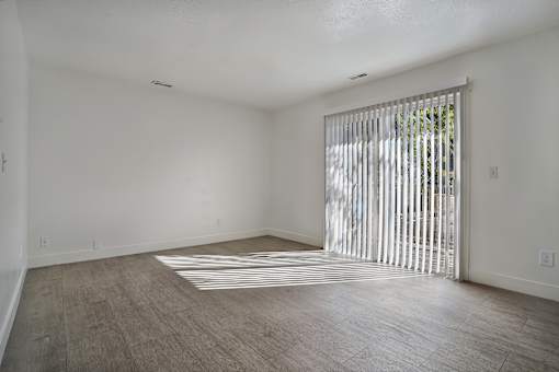 A room with a sliding door and wooden flooring.