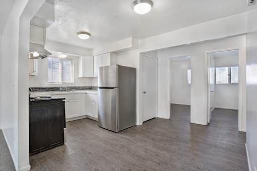 A kitchen with a black countertop and stainless steel appliances.