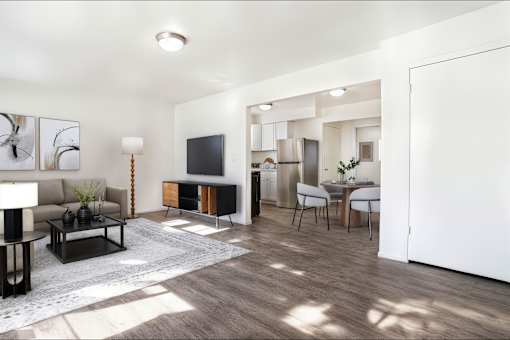A modern living room with a brown sofa and a grey rug.